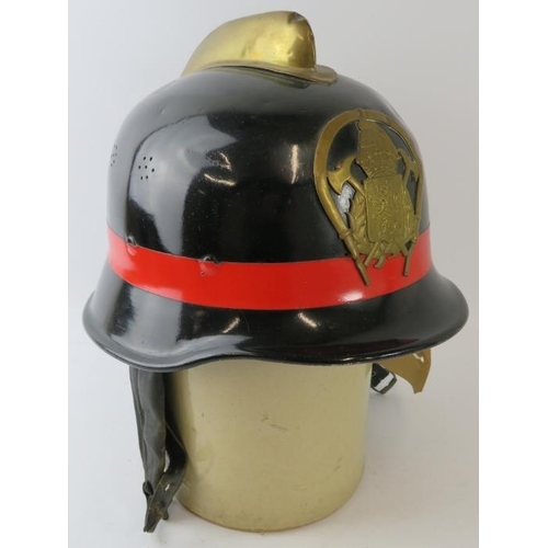 68 - A 1970s Spanish Fire Service black steel fire helmet with brass comb and badge