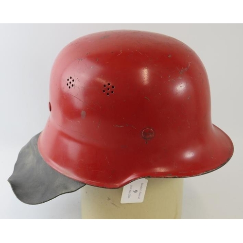 9 - A 1960s German steel red fire helmet with leather neck cowl