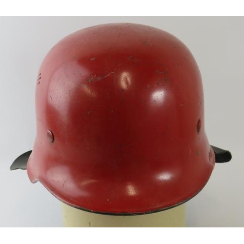 9 - A 1960s German steel red fire helmet with leather neck cowl