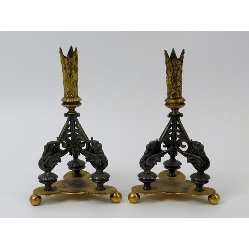 136 - A pair of gilt metal and silver plated triform candlesticks, 19th century. Modelled with mythical be... 