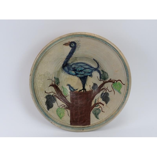 234 - A Mediterranean sgraffito decorated bowl, 20th century. Depicting a peacock with young perched on a ... 