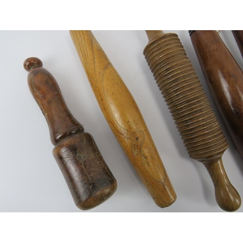 244 - Treen: Seven antique and vintage turned and carved wood rolling pins and a pestle, 19th/20th century... 