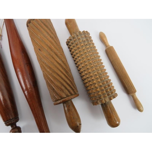 244 - Treen: Seven antique and vintage turned and carved wood rolling pins and a pestle, 19th/20th century... 