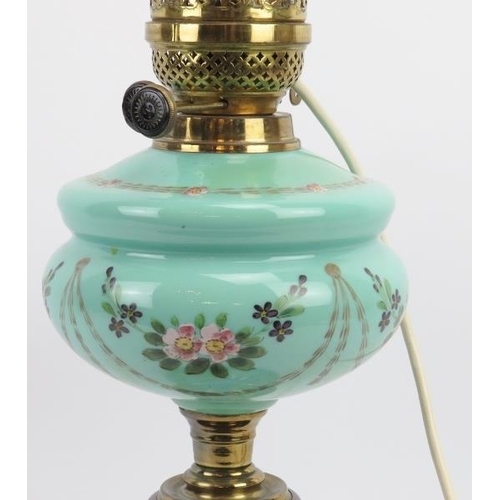 33 - A Late Victorian brass oil lamp. With glass funnel and hand painted opaque glass reservoir. Converte... 