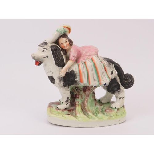 49 - A rare Staffordshire porcelain figural group depicting a girl riding a spaniel dog, mid 19th century... 