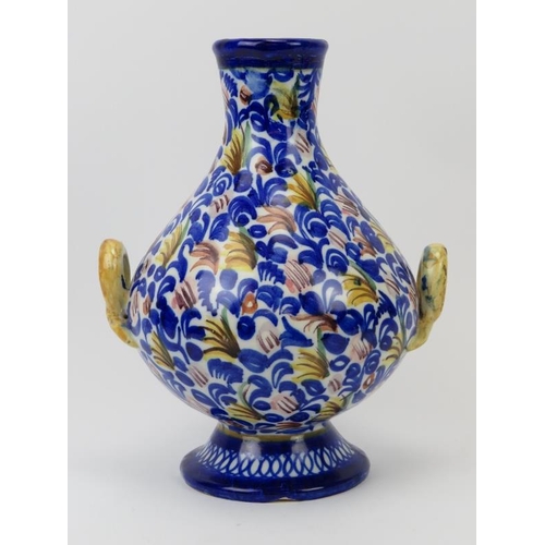 56 - A Moroccan twin handled foliate decorated ceramic vase. 27 cm height. Co9ndition report: Some age re... 