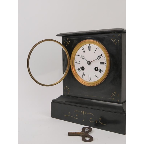 57 - A late Victorian black slate mantel clock. Key and pendulum included. 22 cm height. Condition report... 