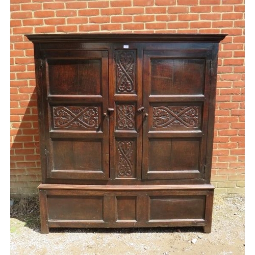 709 - A 17th century oak livery cupboard of good colour, having relief carved decoration and fielded side ... 