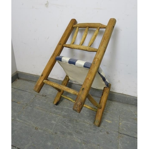 760 - An antique chestnut primitive child’s chair, reupholstered in navy checked material, on whittled sup... 