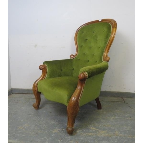 784 - A Victorian pale mahogany spoonback armchair, upholstered in buttoned green velvet material, on scro... 