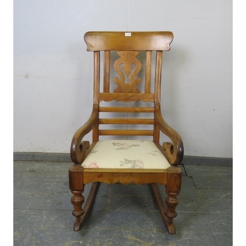 785 - A Victorian walnut rocking chair, having a shaped and pierced back splat, joined with scrolled arms ... 