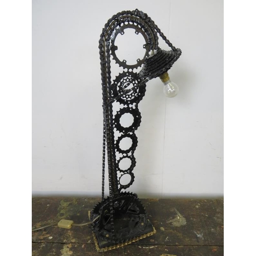 797 - A large table lamp fashioned from a bicycle chain and gears, painted black. 
H68cm W24cm D21cm (appr... 