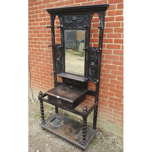 804 - A Victorian ebonised hallstand, relief carved with acanthus leaves and lion masks, the central bevel... 