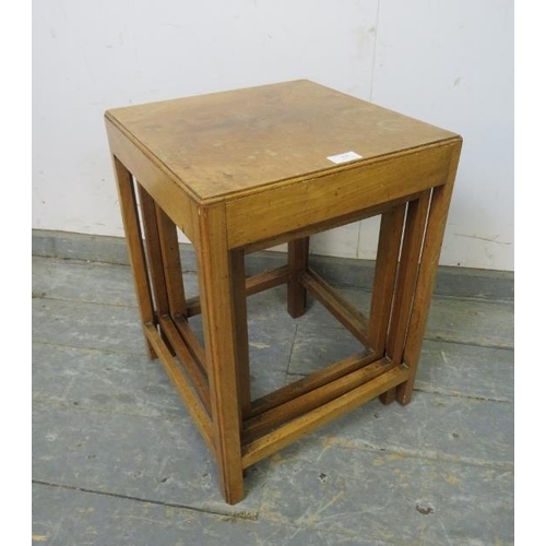 809 - An Art Deco Period walnut nest of three graduated stacking tables, on reeded square supports with st... 