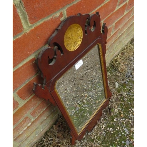 827 - A Georgian parcel gilt wall mirror, within a shaped mahogany surround. 
H65cm W39cm (approx).
Condit... 