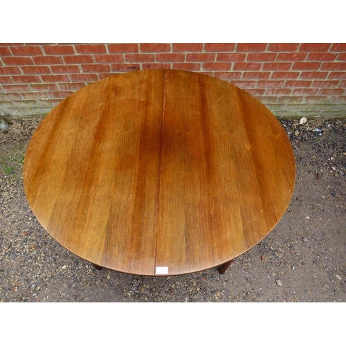 848 - A mid-century circular extending dining table by McIntosh, with butterfly folding central leaf, on t... 