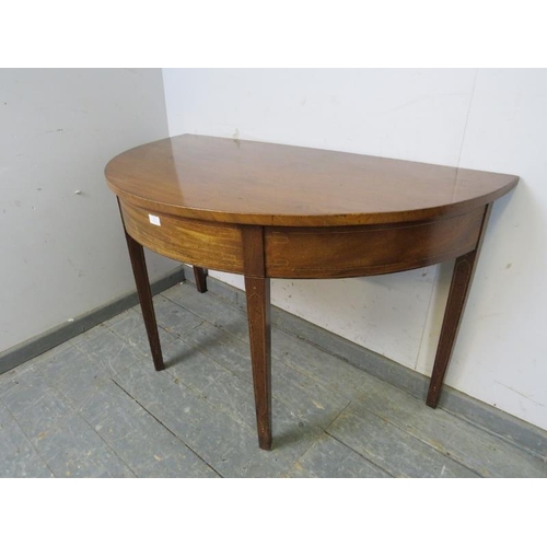 866 - A George III mahogany demi-lune console table, strung with satinwood and boxwood, on tapered square ... 