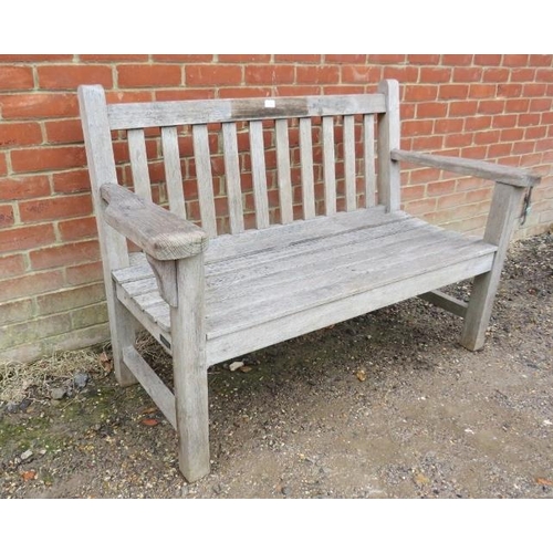 888 - A good quality weathered teak two-seater garden bench by Barlow Tyrie, the slatted seat on square su... 