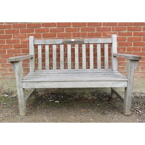 888 - A good quality weathered teak two-seater garden bench by Barlow Tyrie, the slatted seat on square su... 