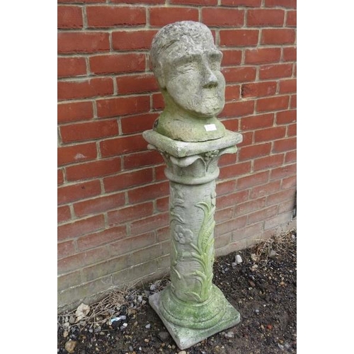 900 - A primitive sandstone sculpture modelled as a head, on an associated reconstituted column with relie... 