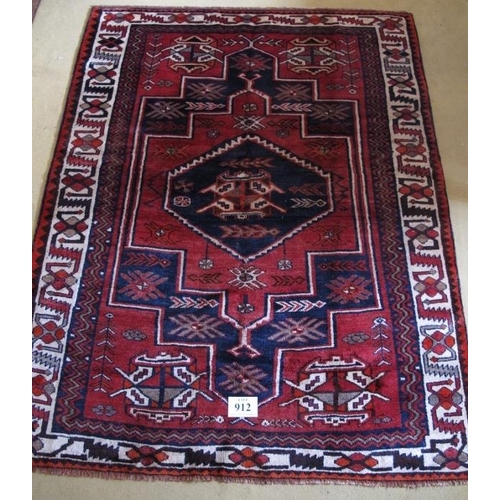 912 - South West Persian Lori rug.  Central six sided motif, blue on mellow red ground, geometric pattern.... 