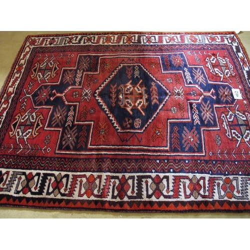 912 - South West Persian Lori rug.  Central six sided motif, blue on mellow red ground, geometric pattern.... 