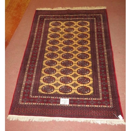 915 - A Persian rug, central repeat pattern on cream ground on red, with wide borders. 181cm x 127cm (appr... 