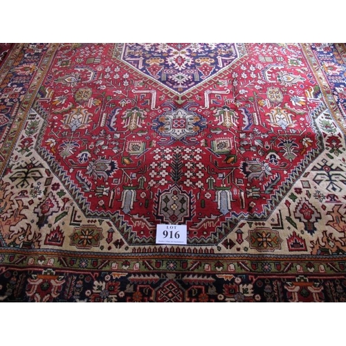 916 - A Persian Tabriz central hexagonal medallion on red ground with wide blue borders. 309cm x 204cm (ap... 