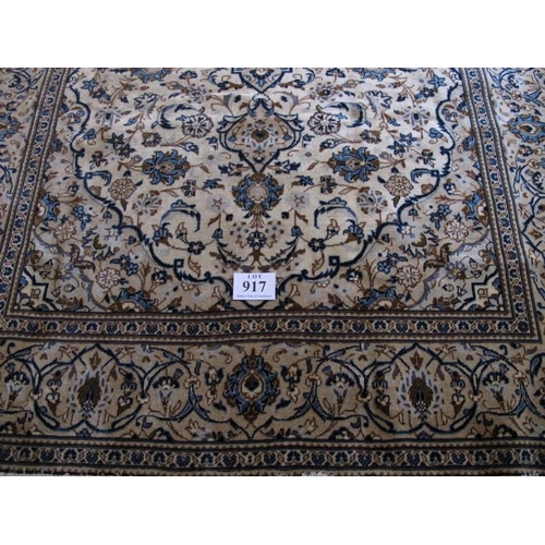 917 - A Persian Kashan carpet, central motif on a floral patterned design, blue on cream. 300cm x 198cm (a... 