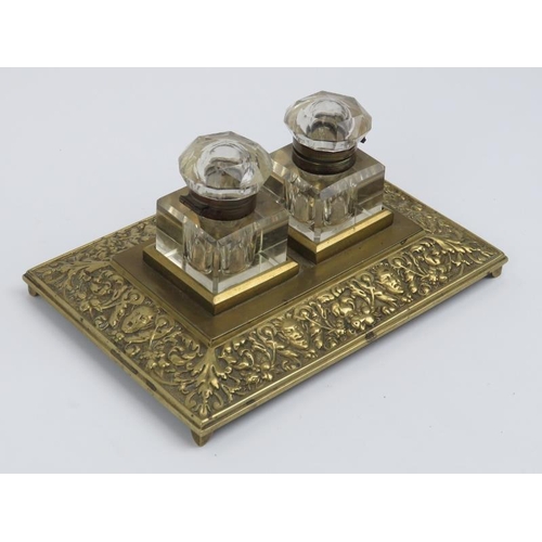 102 - A Victorian brass desktop inkwell stand. The two glass inkwells with hinged covers. 21.8 cm length. ... 