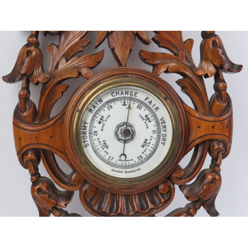 11 - A Victorian foliate carved aneroid barometer with clock. Incorporated with an inscribed presentation... 