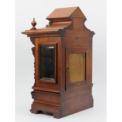 18 - A German mahogany mantel clock, late 19th century. The architectural case with bevelled glass window... 