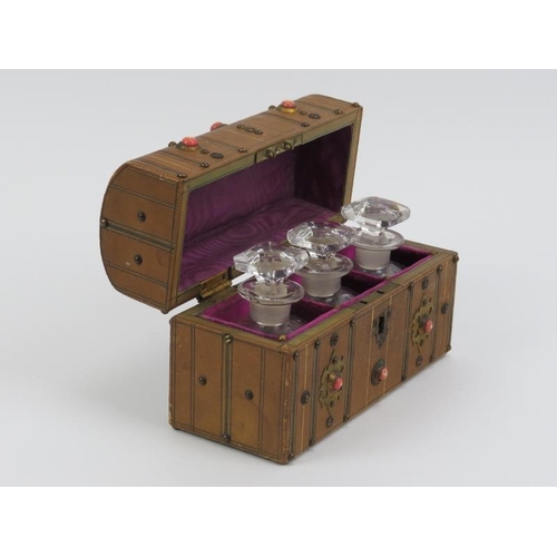 3 - A Victorian travelling scent bottle casket. Of chest form with studded brass work and cabochons, the... 