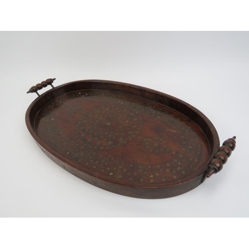 35 - An Anglo-Indian foliate brass inlaid hardwood twin handled serving tray, 19th century. 61 cm length.... 