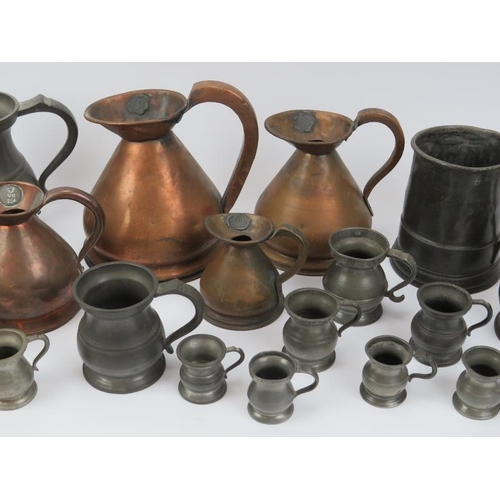 69 - A large collection of pewter and copper tankards, jugs and measures, 19th century. (22 items) 19.7 c... 