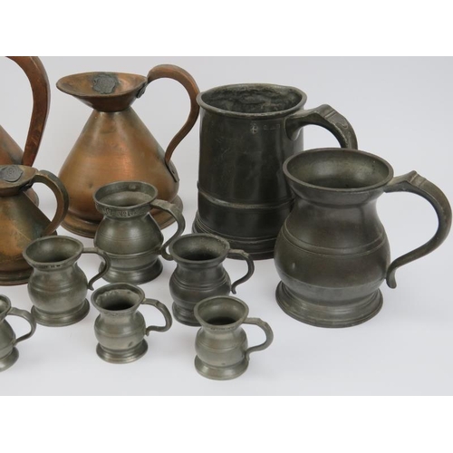 69 - A large collection of pewter and copper tankards, jugs and measures, 19th century. (22 items) 19.7 c... 