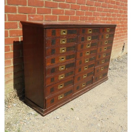 701 - A 19th Century mahogany haberdashery bank of 24 drawers, having brass campaign style handles and han... 