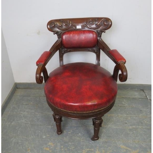 702 - A William IV mahogany revolving desk chair, the carved back joined with scrolled arms to a to a revo... 