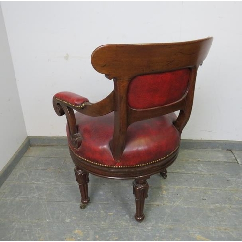 702 - A William IV mahogany revolving desk chair, the carved back joined with scrolled arms to a to a revo... 