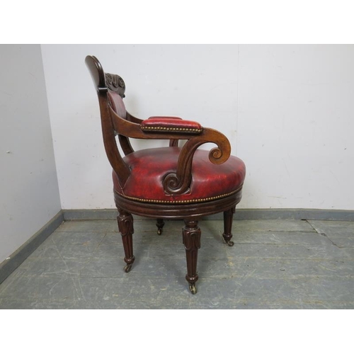 702 - A William IV mahogany revolving desk chair, the carved back joined with scrolled arms to a to a revo... 