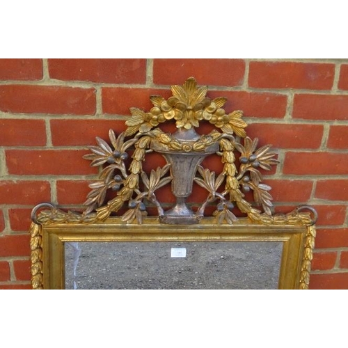 703 - A large vintage giltwood bevelled wall mirror, the pierced cornice modelled as a Classical urn flank... 