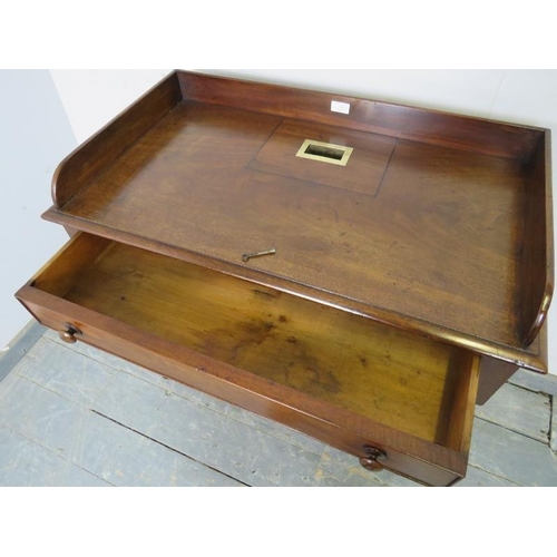 708 - A rare Georgian mahogany rent table, the ¾ gallery enclosing a brass bound slot, housing one long co... 