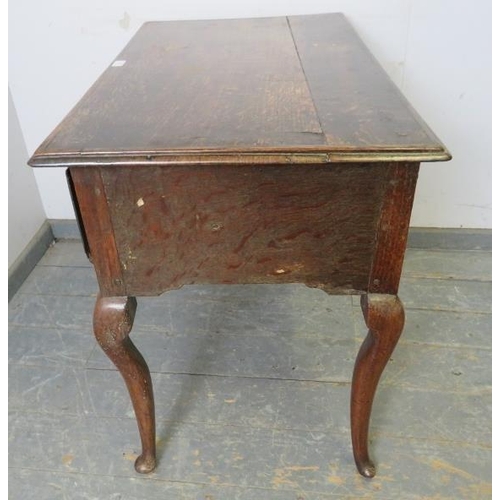 709 - An early 18th century oak lowboy, housing three short drawers with brass handles, above a shaped apr... 