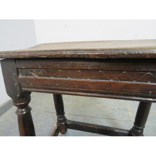 713 - A 17th century oak joint stool, the carved frieze above turned supports united by stretchers. 
H56cm... 