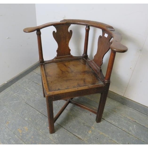 714 - An 18th century oak corner chair, the shaped back jointed with plain uprights and shaped splats to t... 