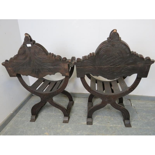 718 - A pair of 19th century oak Savonarola X-frame chairs, ornately carved in the Gothic taste with heral... 