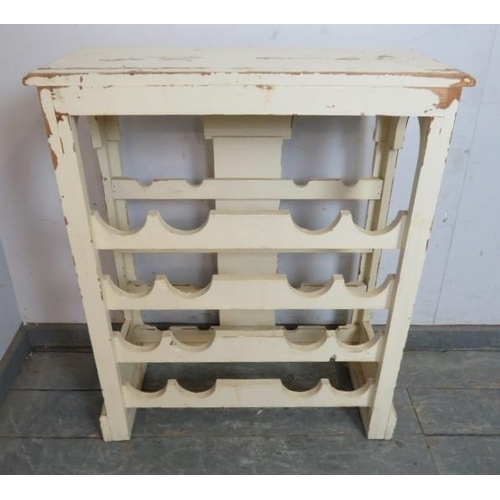 725 - A painted and distressed freestanding wine rack, the relief carved central panel depicting fruiting ... 