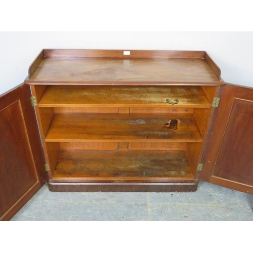 748 - A Victorian mahogany low enclosed bookcase, the ¾ gallery above twin doors with arched panels, openi... 