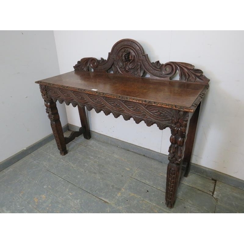 768 - A 19th century Gothic Revival oak console table, the carved and pierced gallery with central grotesq... 