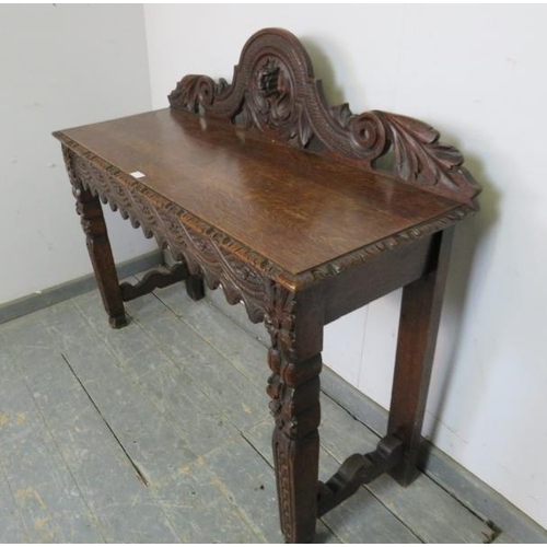 768 - A 19th century Gothic Revival oak console table, the carved and pierced gallery with central grotesq... 